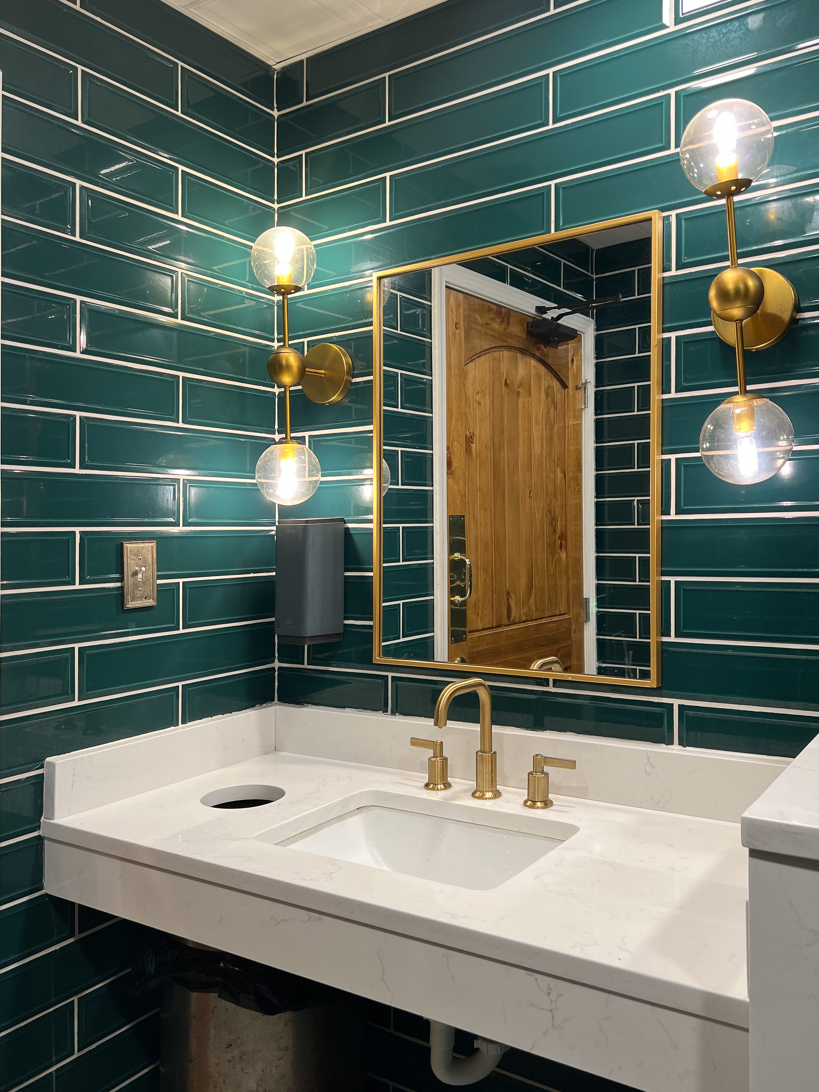 A newly renovated bathroom with green tile - contact Footprints Floors to learn more about the benefits of bathroom tile renovations!