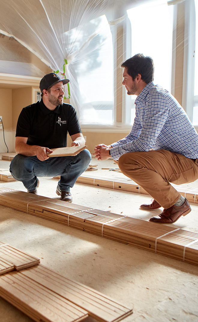 Two Footprints Floors professionals installing flooring in a home for the fall season.