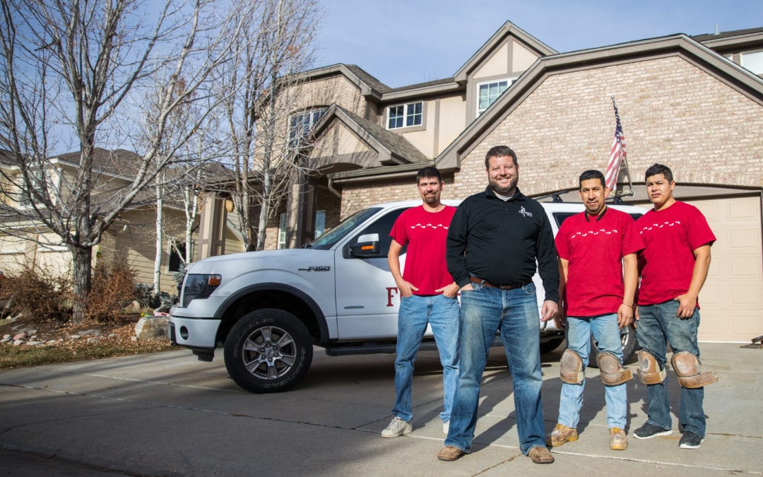 A Footprints Floors truck with Bryan Park and his team standing in front of it.