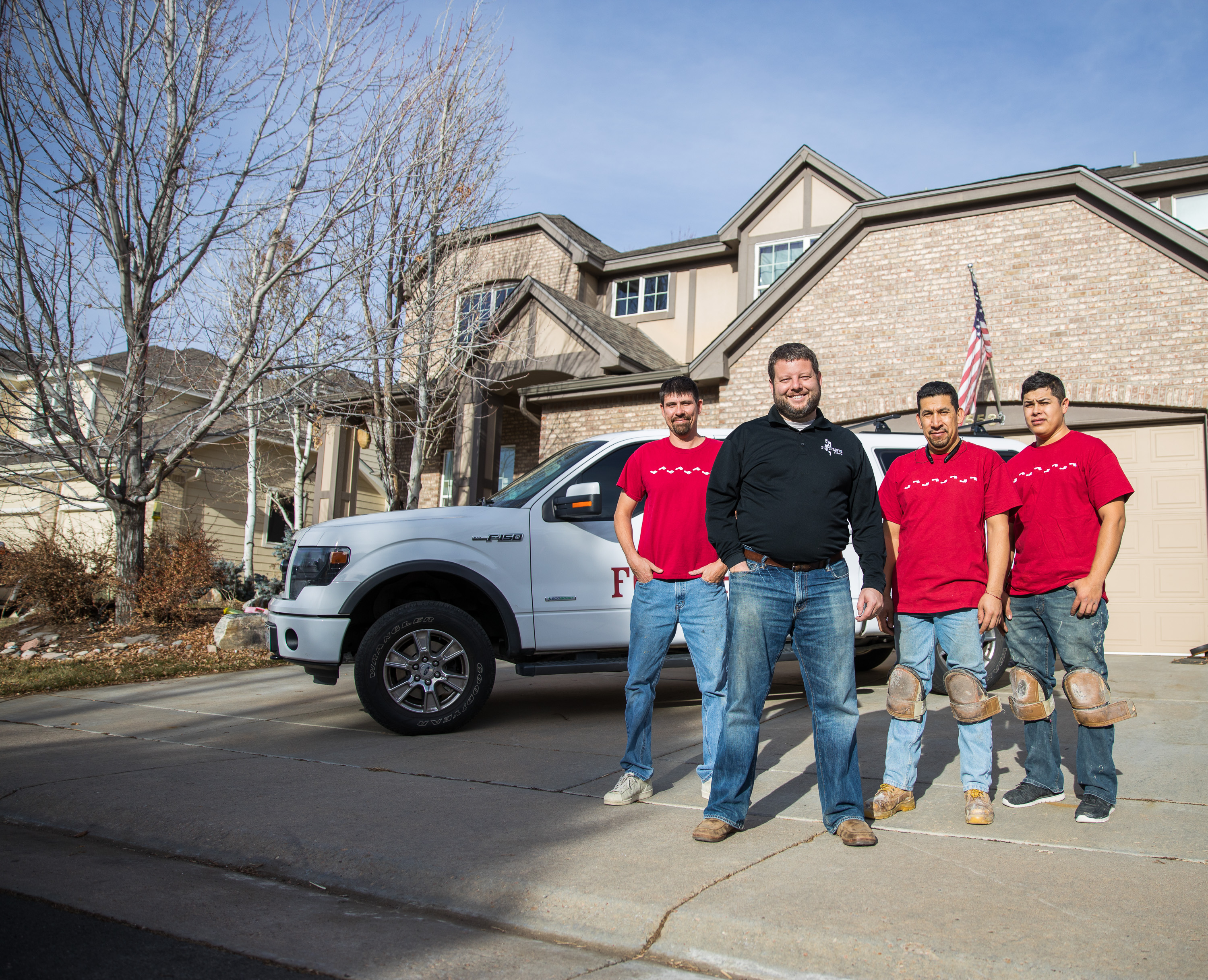 A group of 4 Footprints Floors owners standing on front of a company truck.