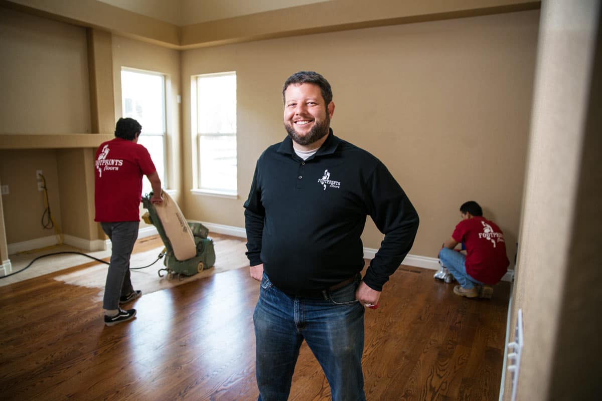 An image of Bryan Park and two Footprints Floors team members working in a newly renovated living room.