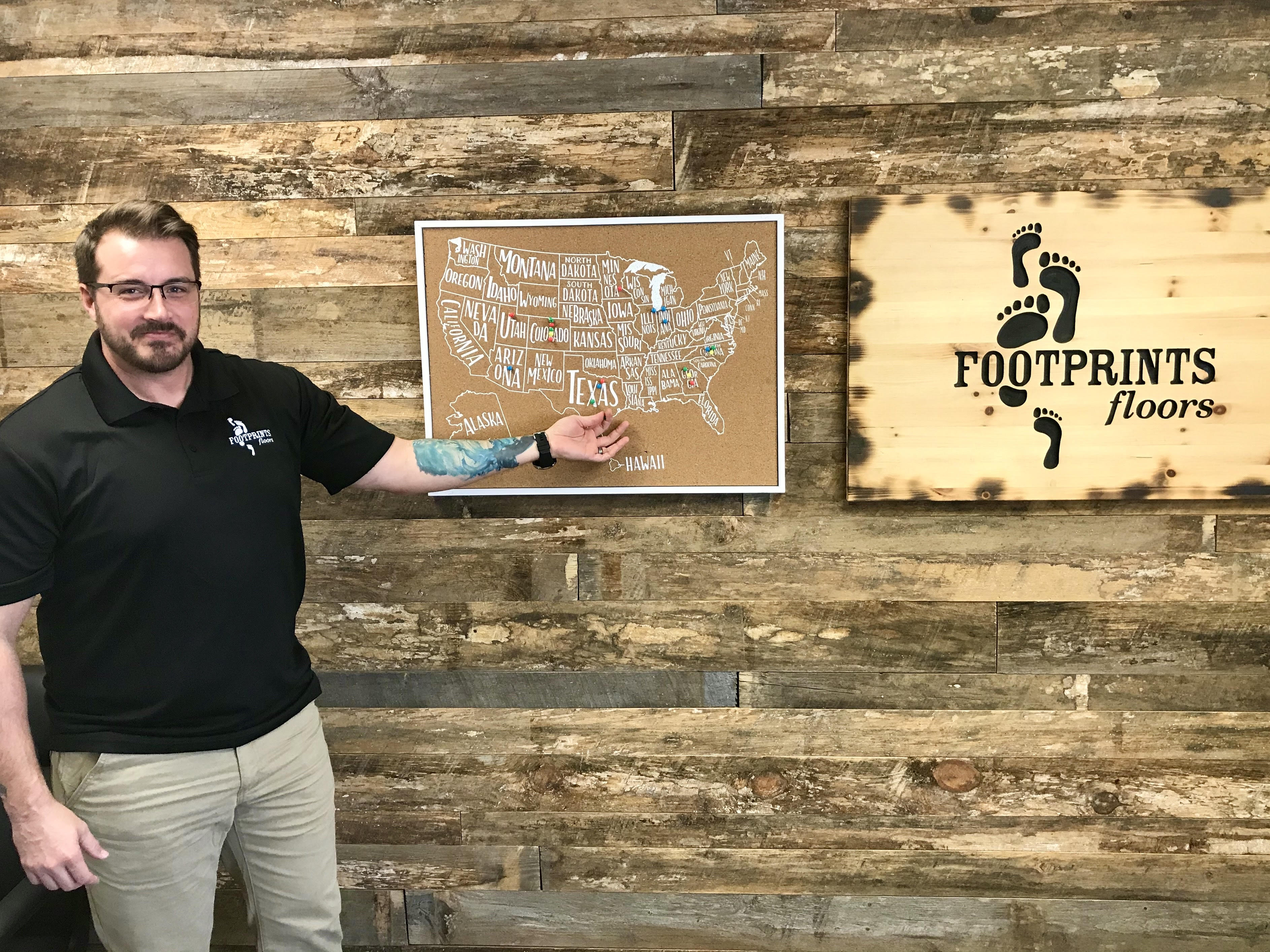 Daniel Wilkinson standing in front of the Footprints Floors franchise map.