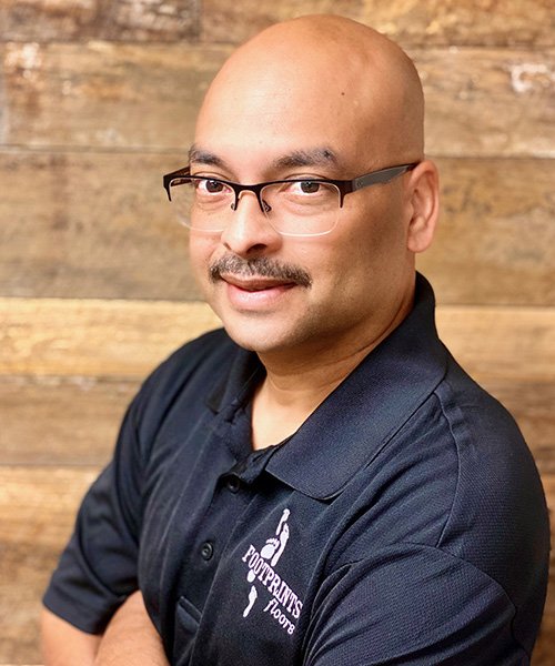 Floyd Khemai standing in front of the Footprints Floors franchise map