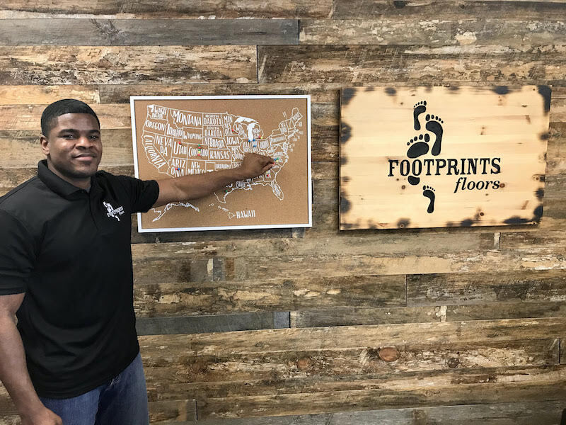 A picture of Ini Esiet at the pin ceremony for the opening of his Footprints Floors location in Gastonia, NC!