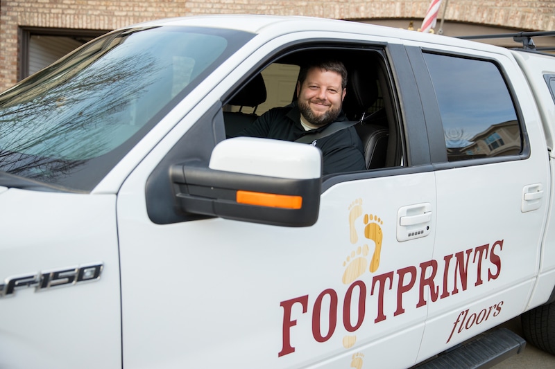 An image of Bryan Park, the founder and CEO of Footprints Floors, in a service vehicle.