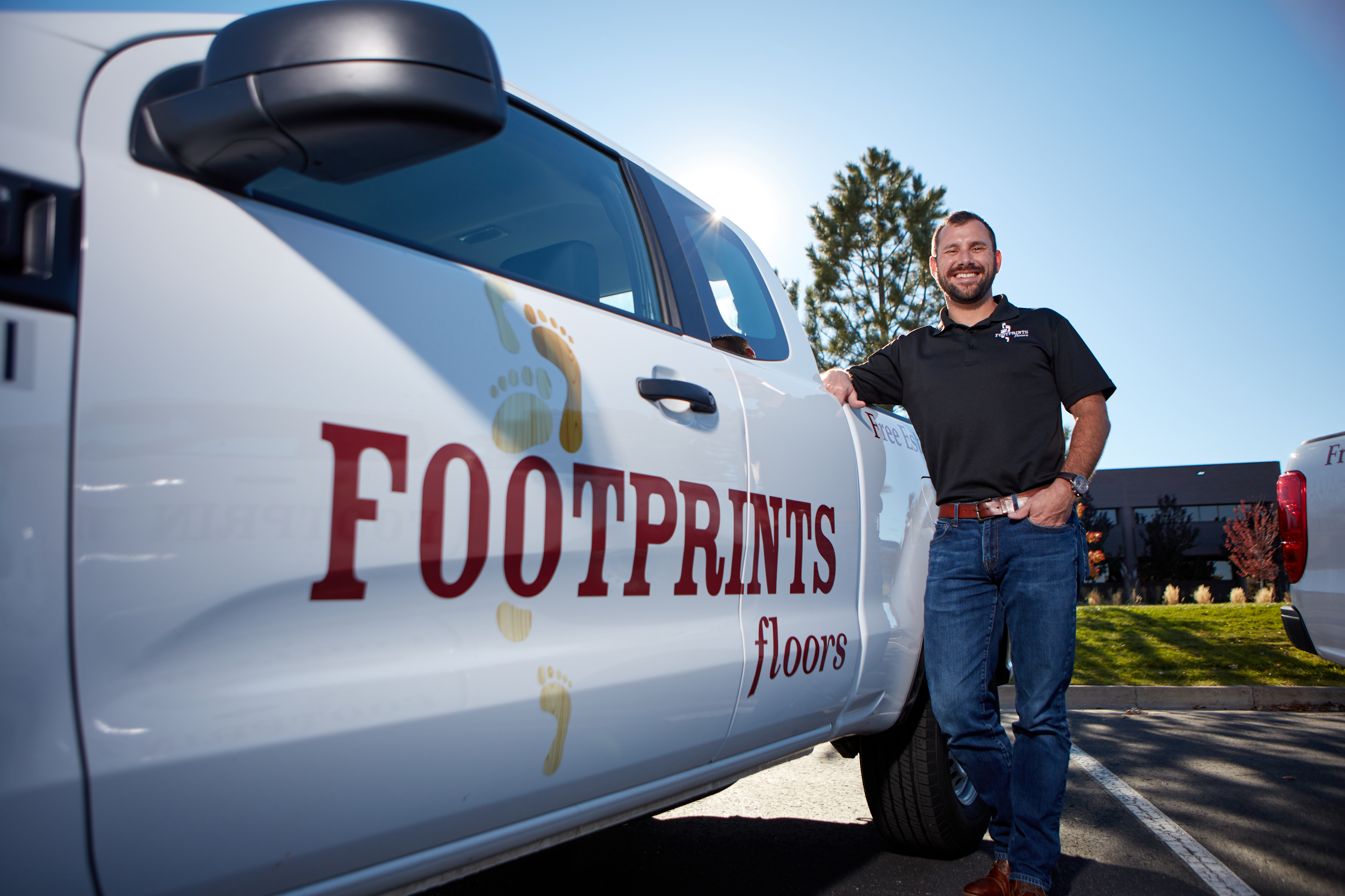 A Footprints Floors owner standing in front of his branded truck - learn why we are one of the best flooring franchises.
