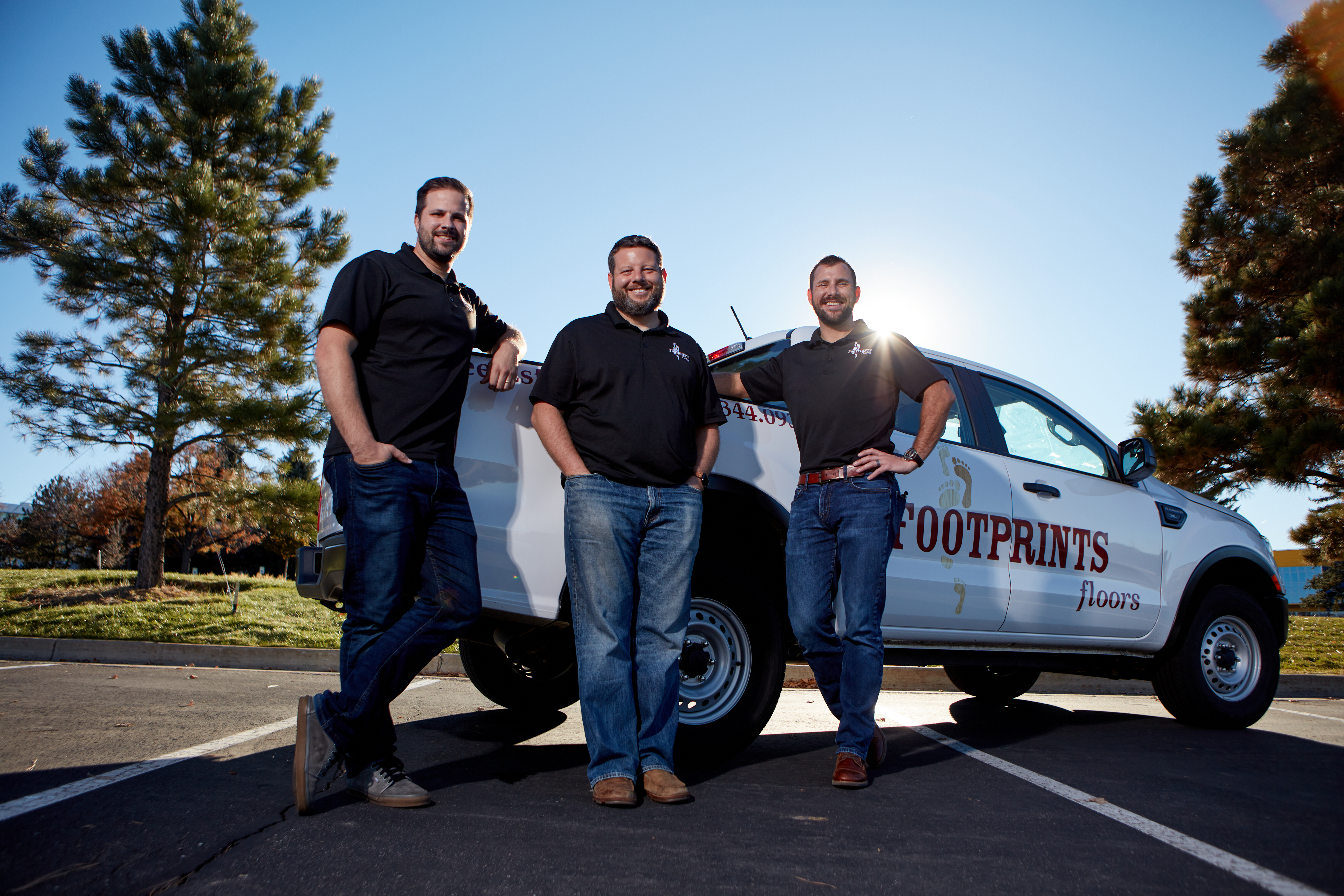 3 Footprints Floors franchisees standing in front of a branded truck.