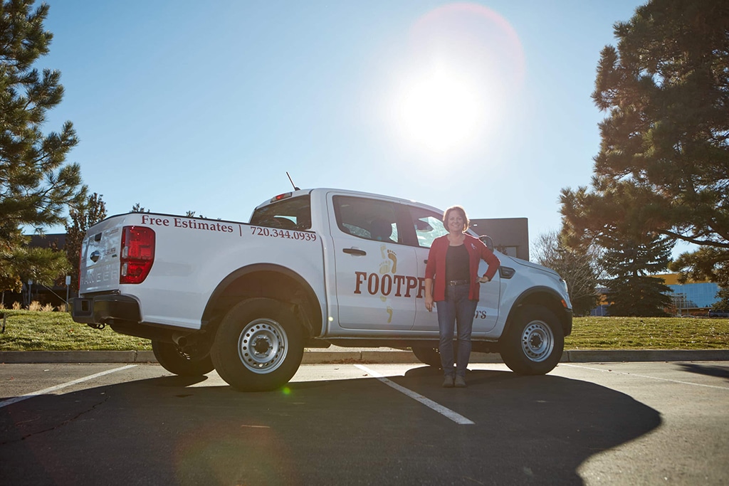 A Footprints Floors owner standing in front of her brand truck.