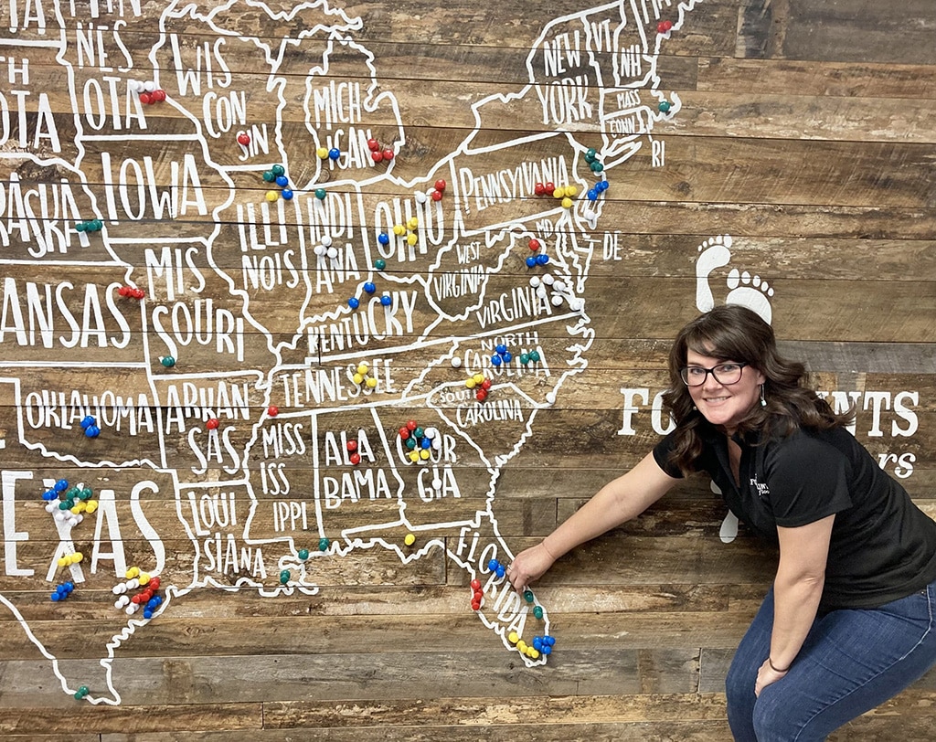 A Footprints Floors team member and a map showing our franchise growth.