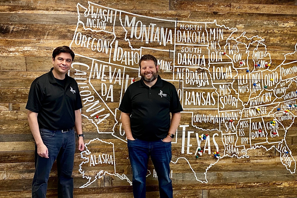 An image of Alfonso Ferreira standing in front of the Footprints Floors franchise map.
