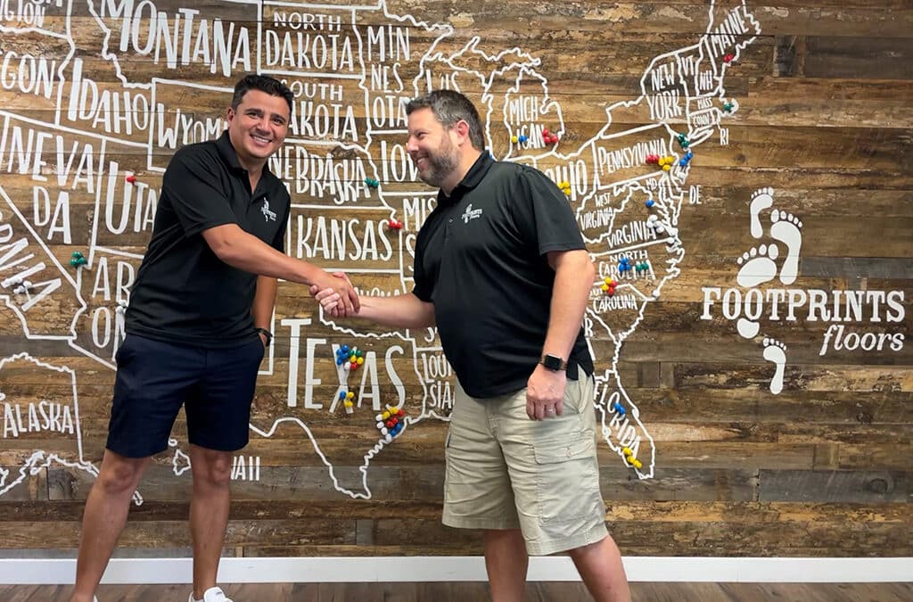 Bryan Park shaking hands with a new franchise owner - find available flooring franchise opportunities with Footprints Floors.