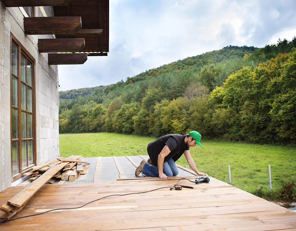 A Footprints Floors team member sanding wood down before a flooring install.
