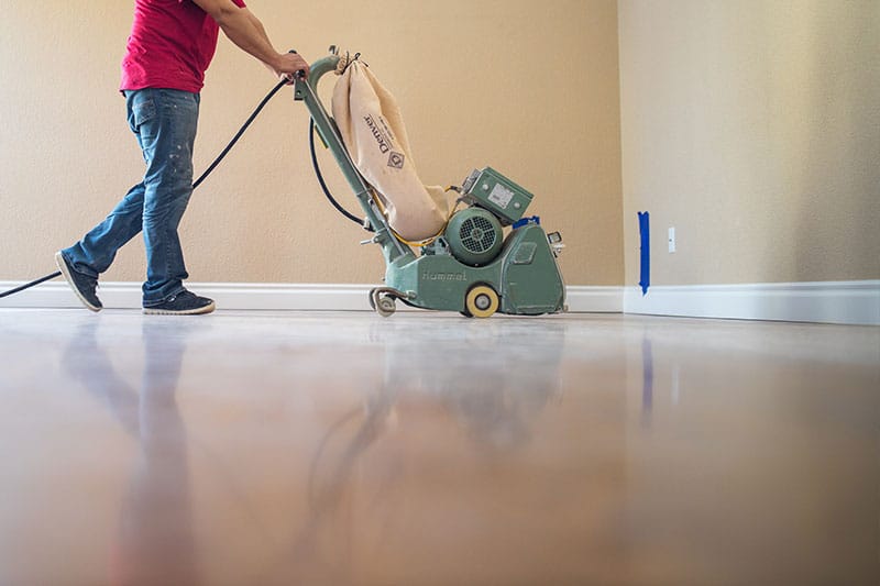 An image of a Footprints Floors team members sanding down wooden floors.