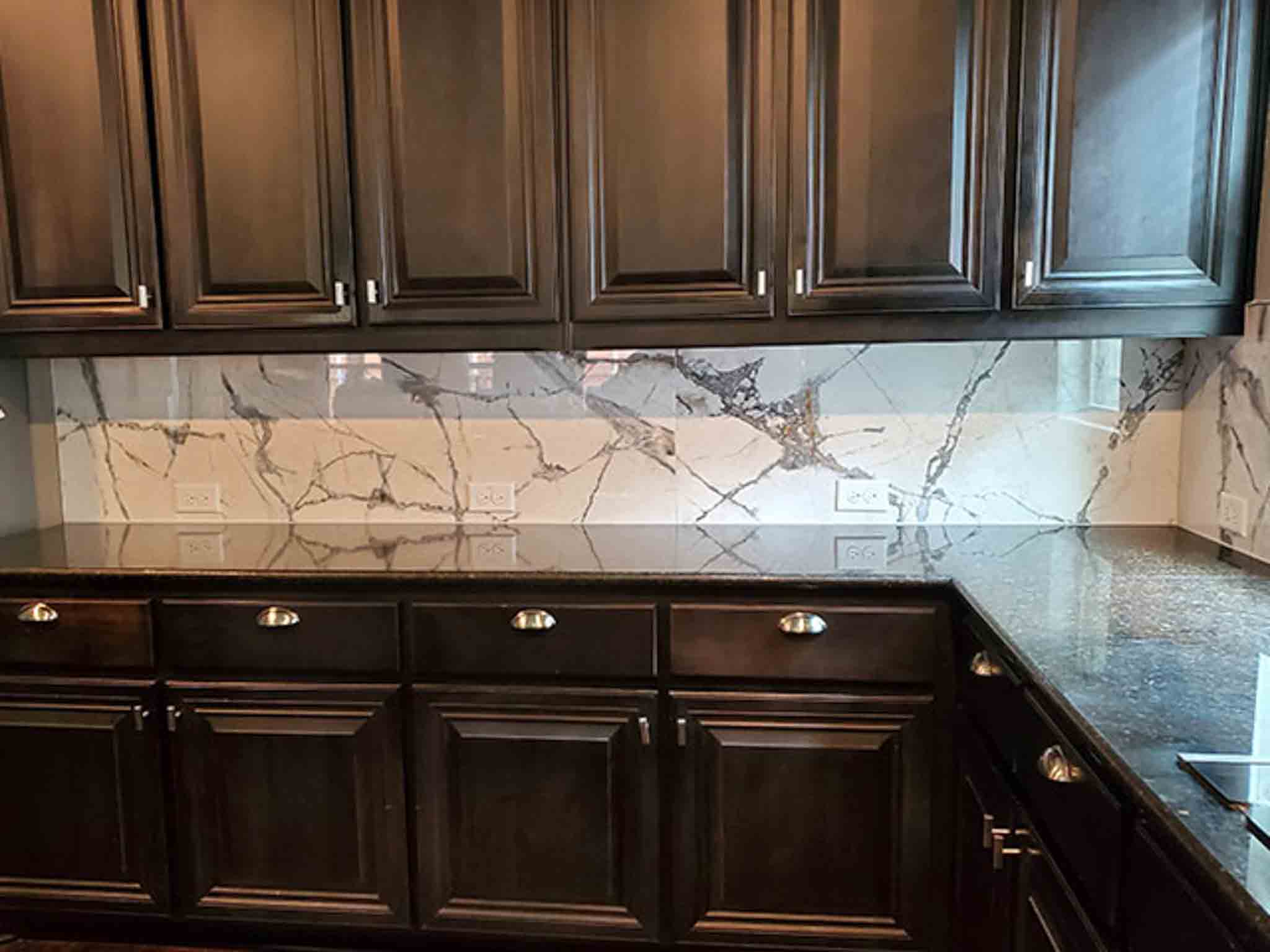 White marble backsplash in a kitchen with wood cabinets. 