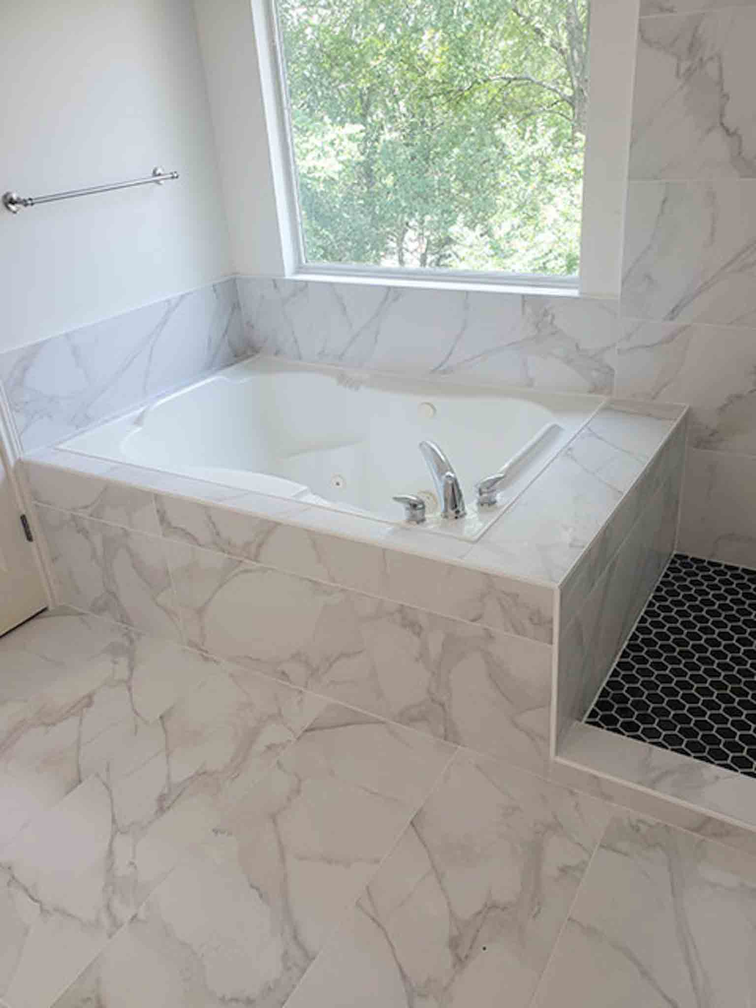 A white tiles bathtub, installed by Footprints Floors of the MidSouth.