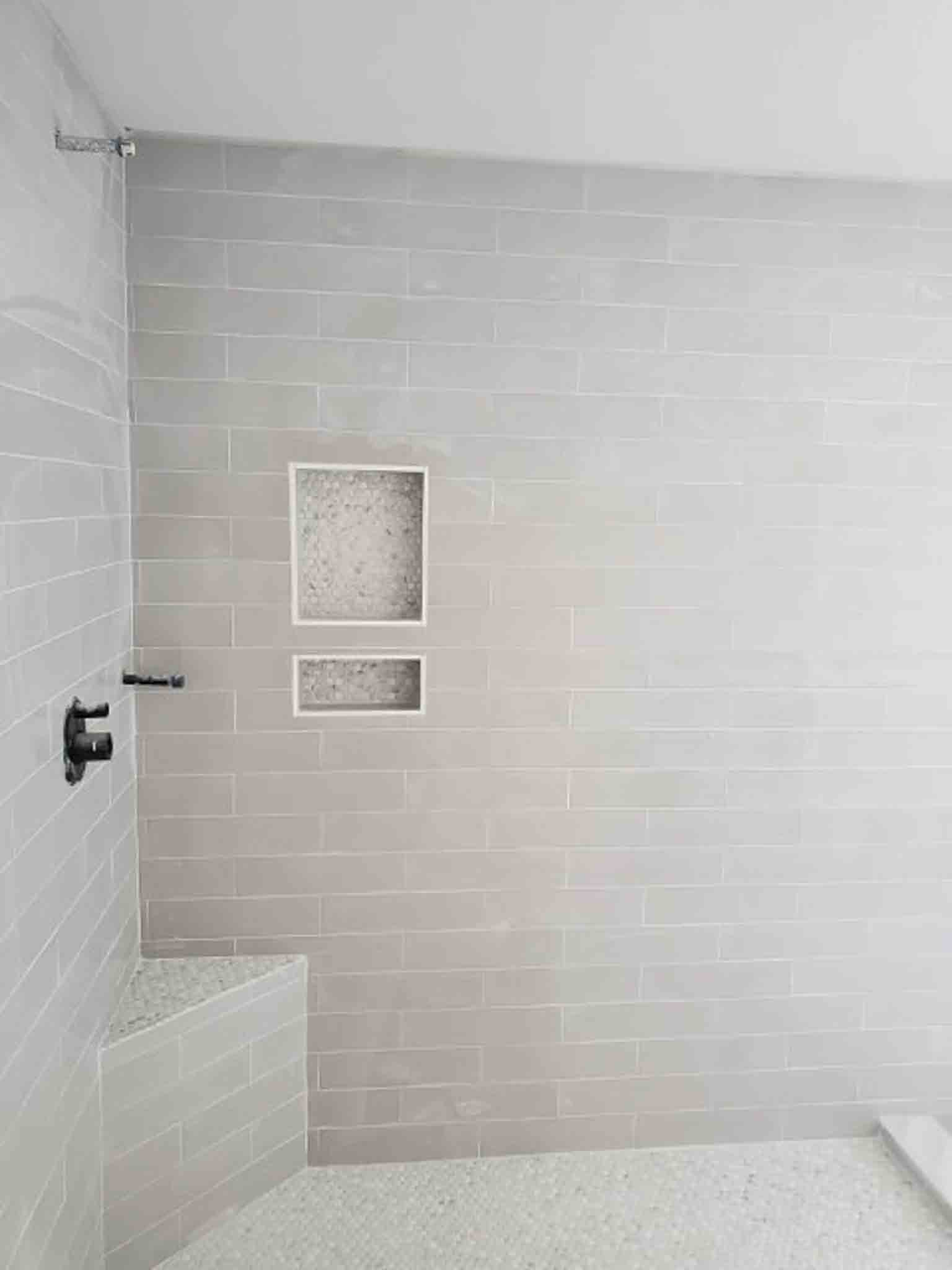 A shower with white tiling, installed by Footprints Floors of the MidSouth.