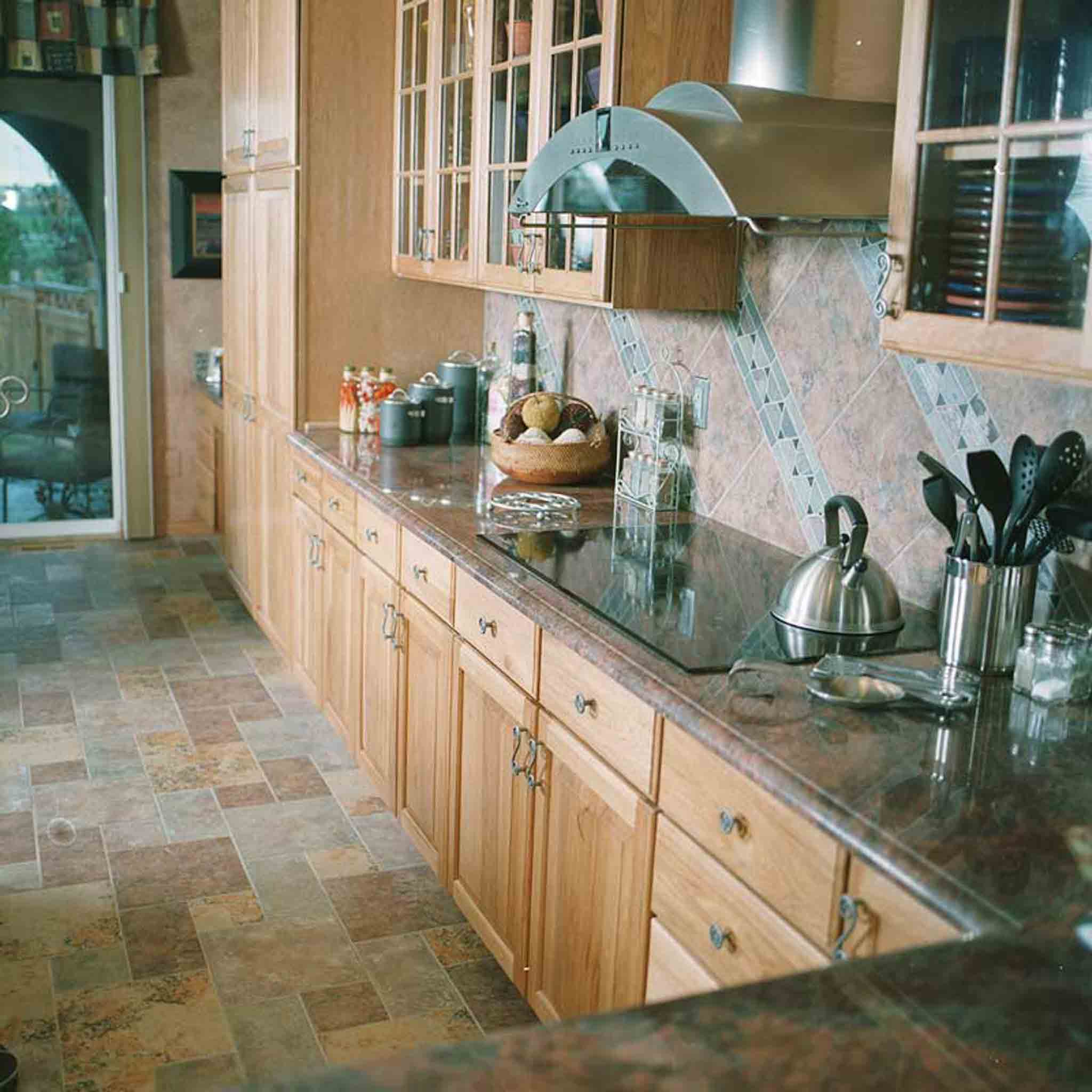 A kitchen with tile flooring and backsplash, installed by Footprints Floors of the MidSouth.