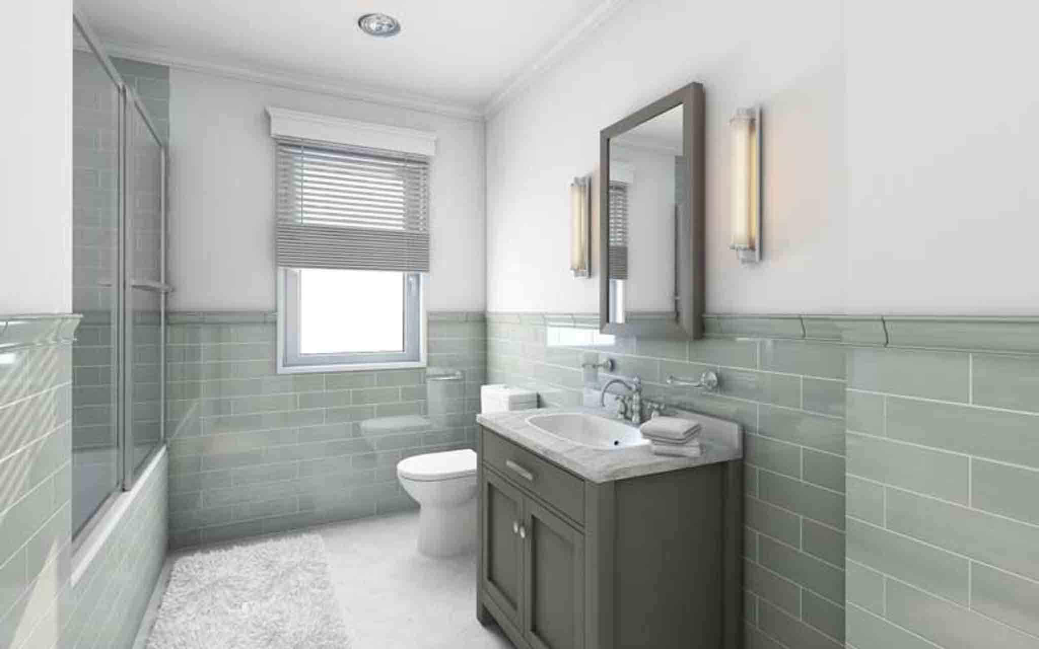 A bathroom with grey cabinets and green a green backsplash.