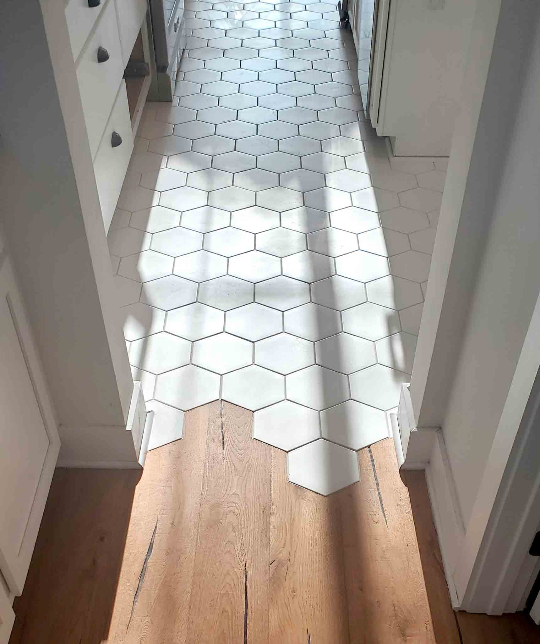 White hexagon tiles and wood flooring, installed by Footprints Floors of the MidSouth.