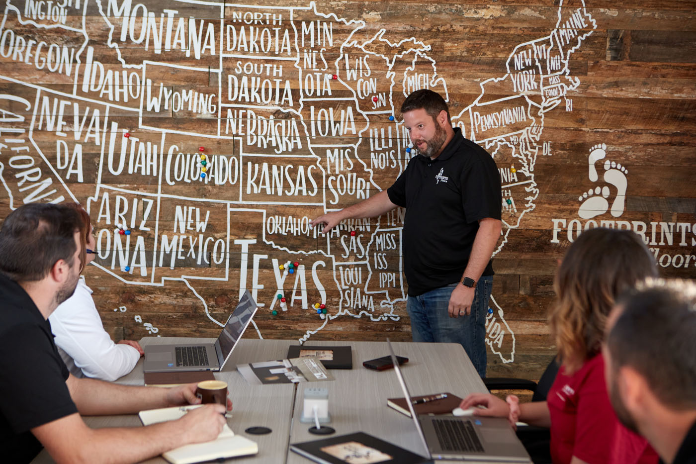 Bryan Park pointing at a map of our franchise locations - take control of your career with a Footprints Floors flooring business.