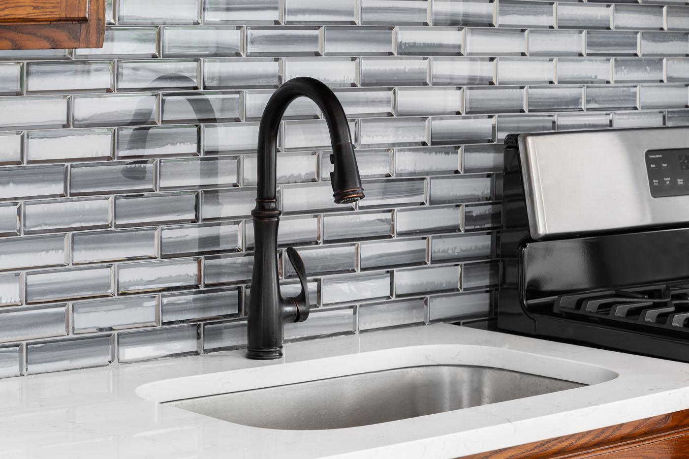 A kitchen with a glass tile backsplash.