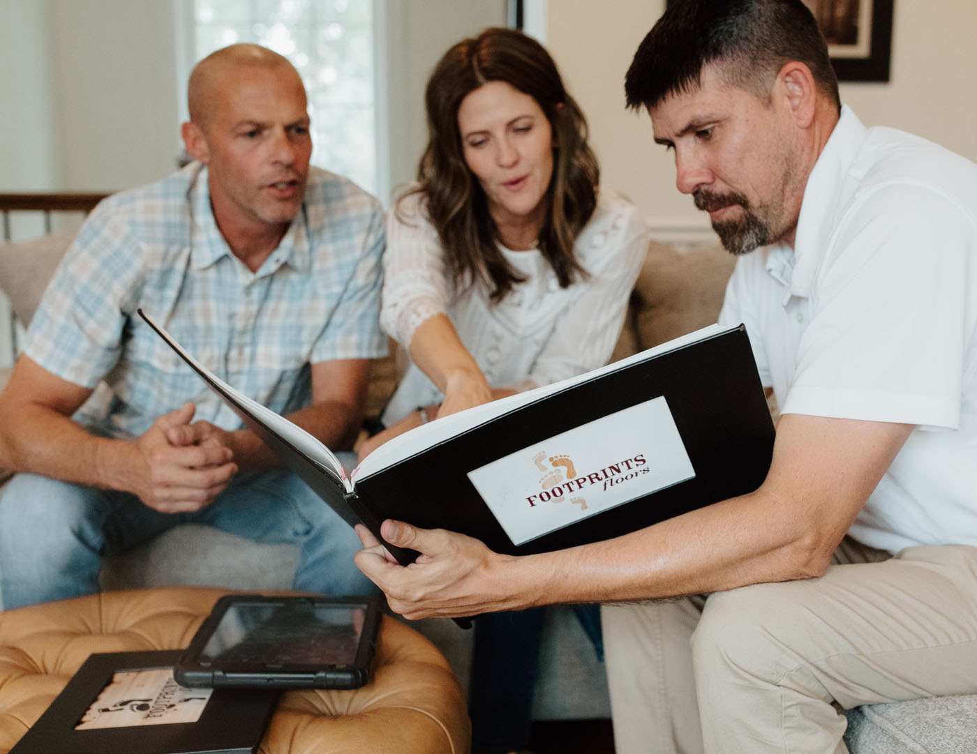 A Footprints Floors technician working with customers to find the perfect tile flooring solution - contact us today to learn how we are more than a tile business for sale!