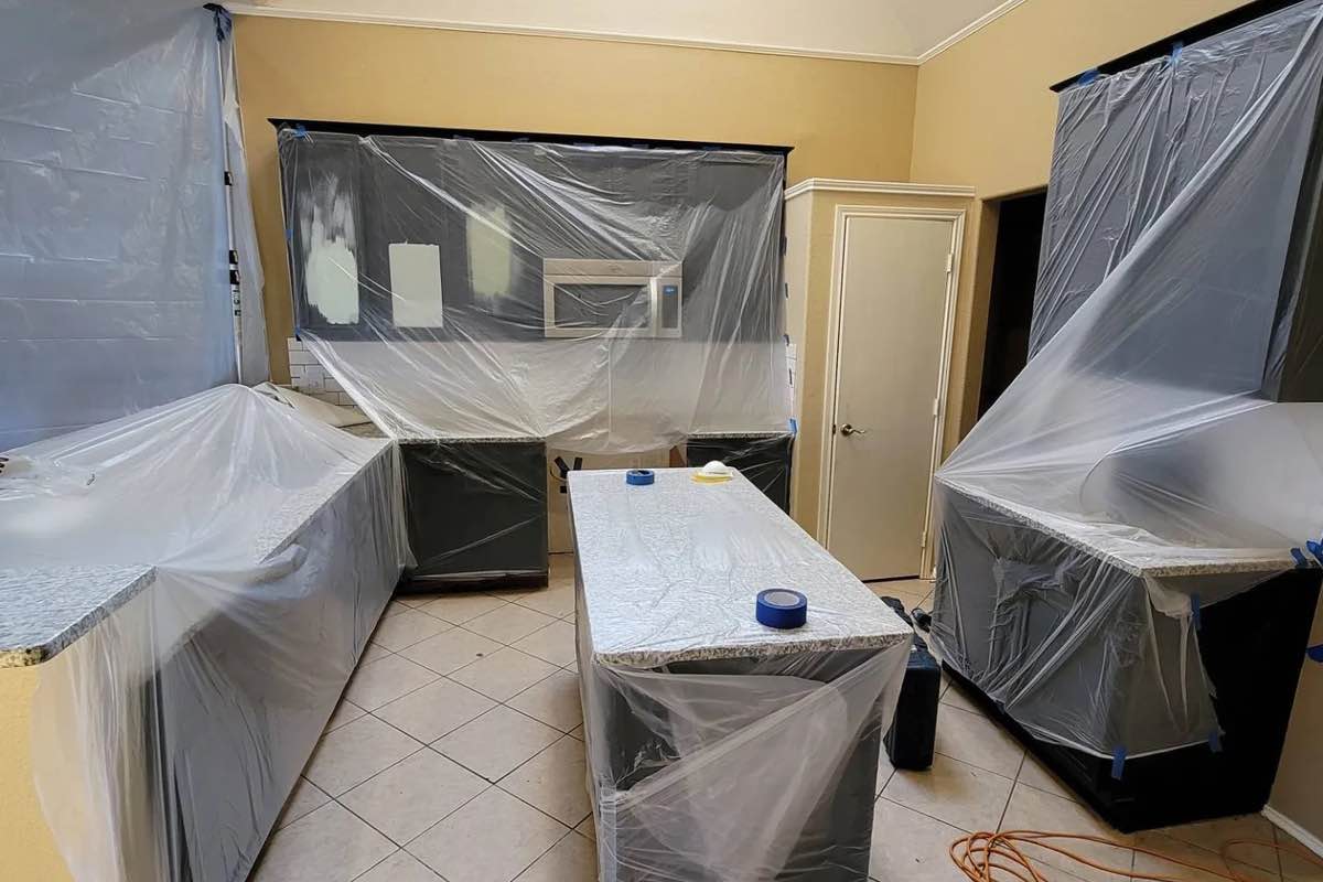A kitchen covered by plastic, choose Footprints Floors for your dustless demo services in McKinney / Plano, TX.