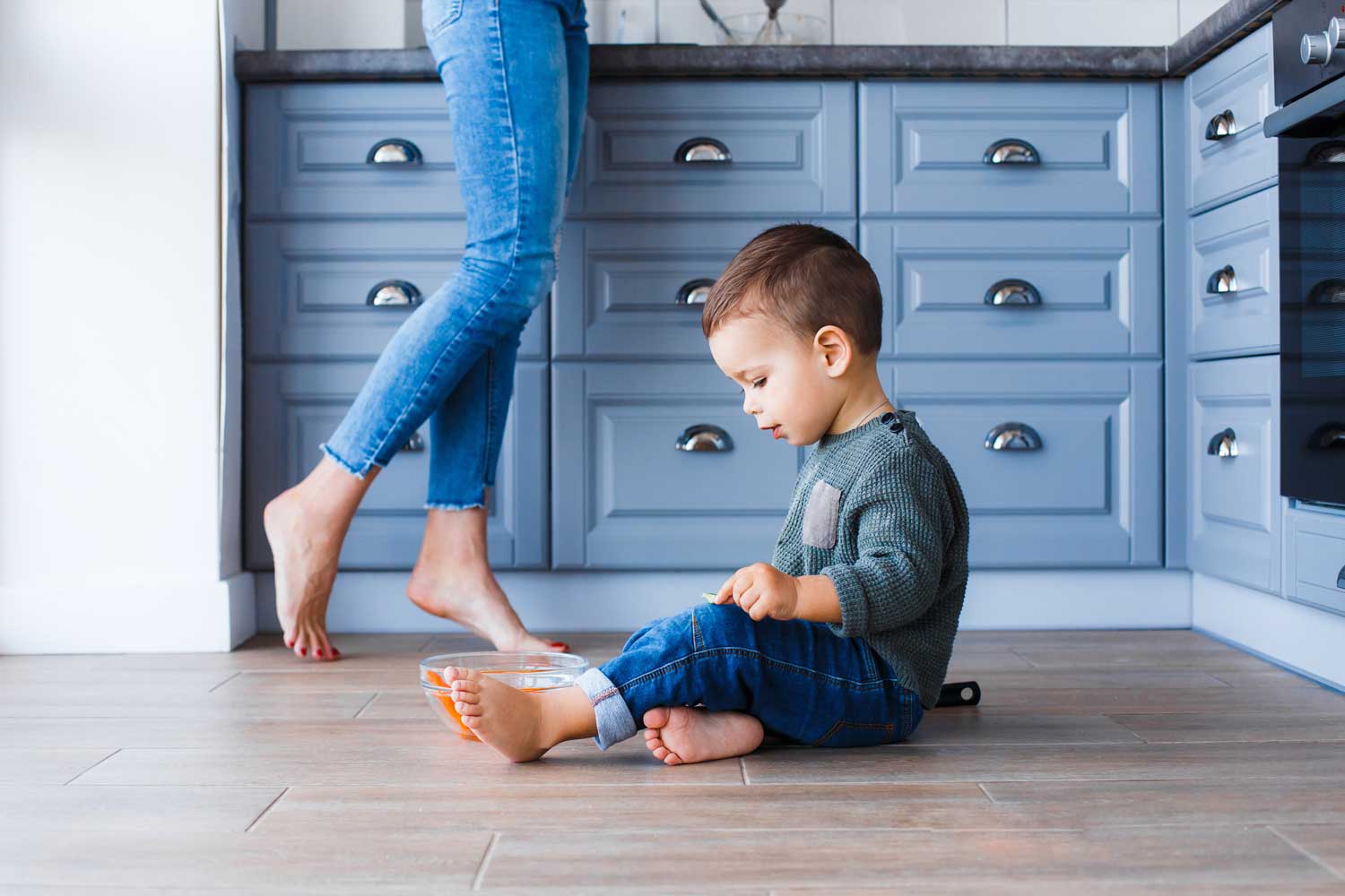 Mom and child barefoot on hardwood to protect from scrapes - learn more with Footprints Floors.