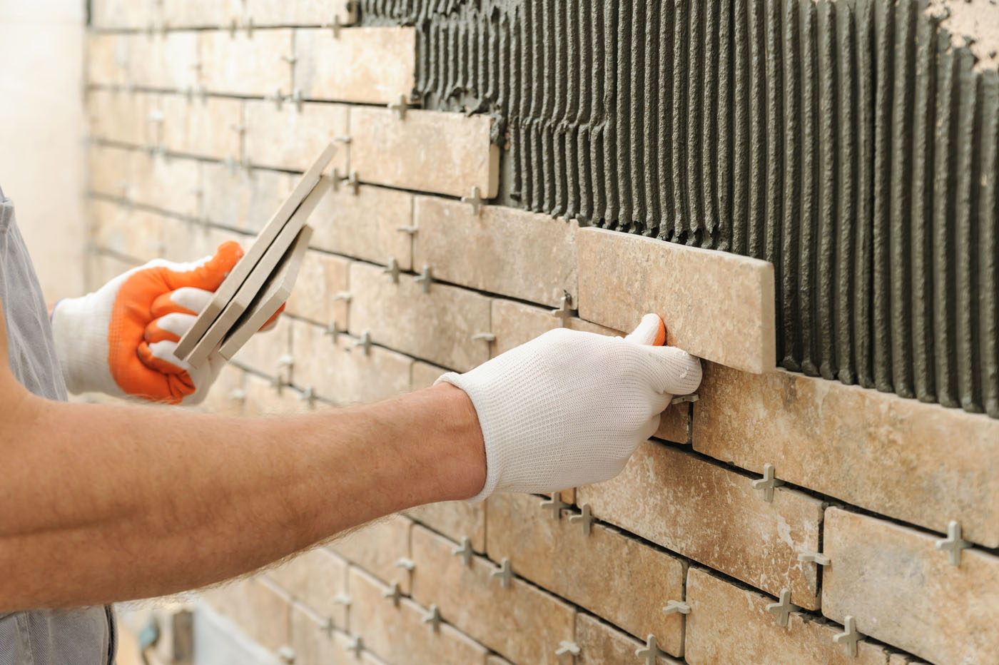 A Reno-Sparks Metro bathroom backsplash installation in progress with an expert from Footprints Floors.