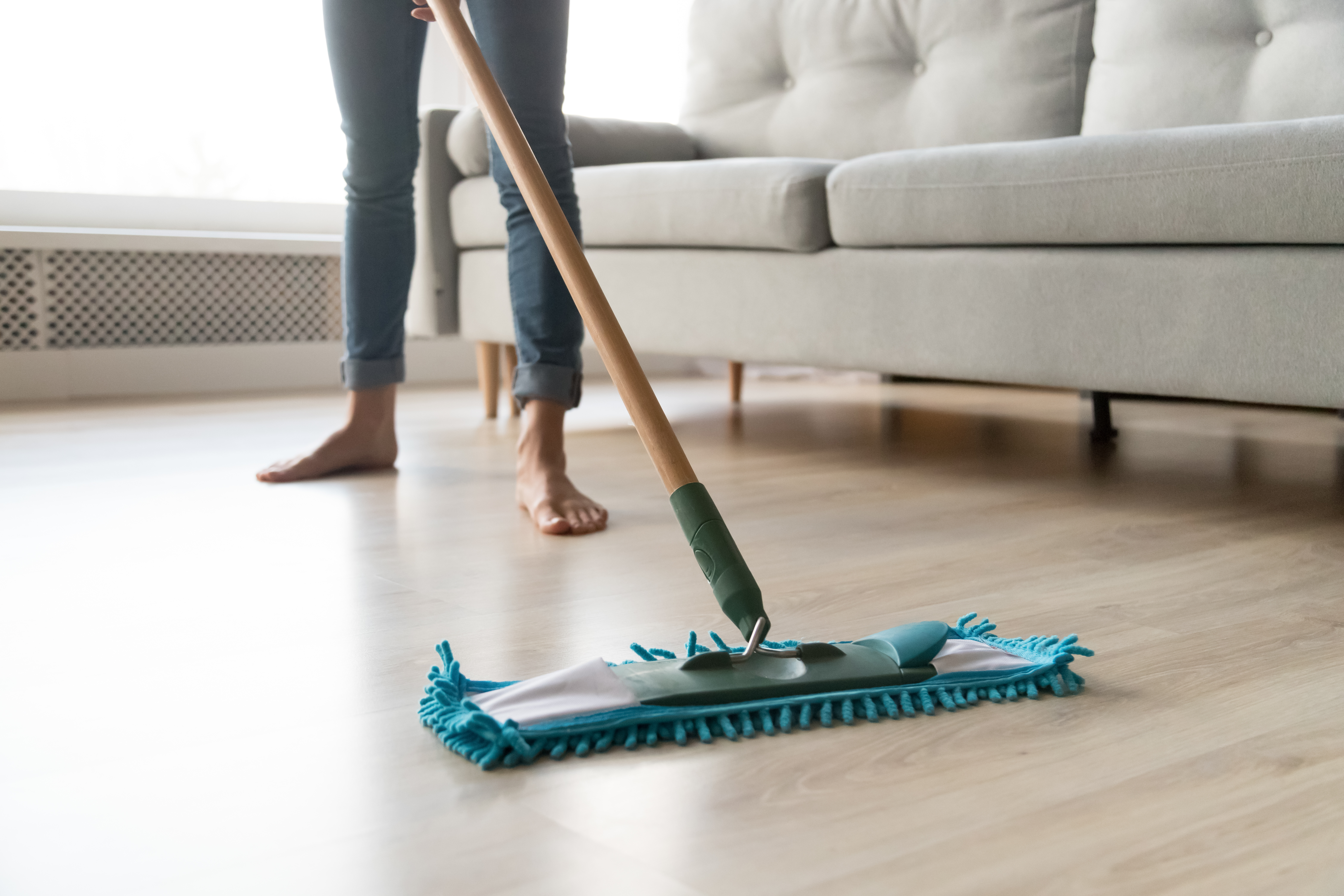 A woman dusting her lamintae floors - for laminate flooring installation in Reno-Sparks Metro, NV, contact Footprints Floors.