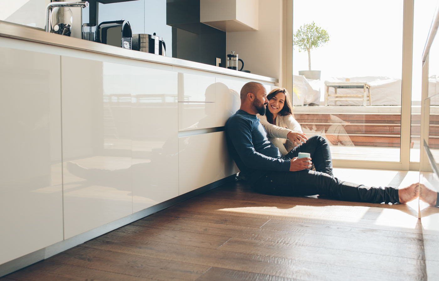 A man and a woman sitting on Footprints Floors flooring - contact us today for vinyl flooring installers in Reno-Sparks Metro, NV.