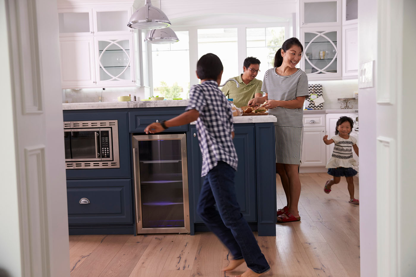 A family of four enjoying their time in the kitchen on Footprints Floors laminate flooring.