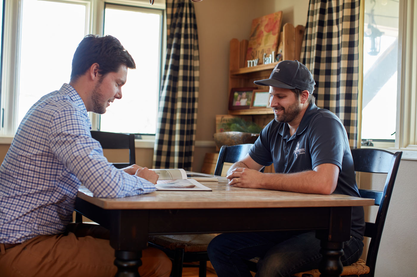A homeowner sitting down with a Footprints Floors of the MidSouth employee, see why customers choose us for flooring and tile installation services in Arlington / Collierville, TN.