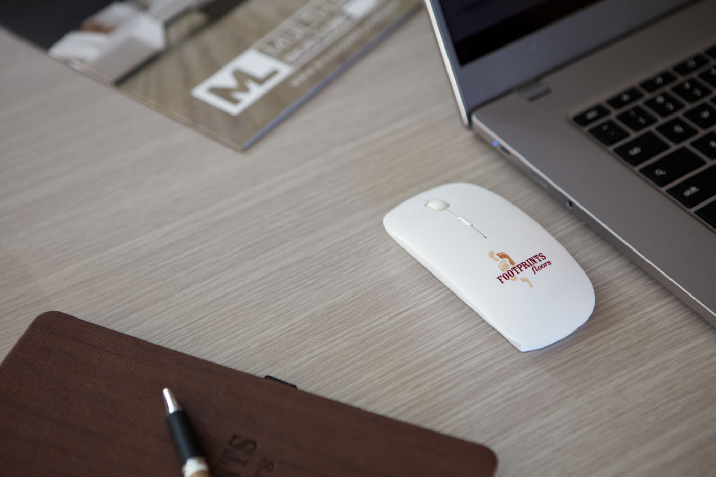 An image of Footprints Floors branded mouse, notebook, and other tools used by our customer support teams.
