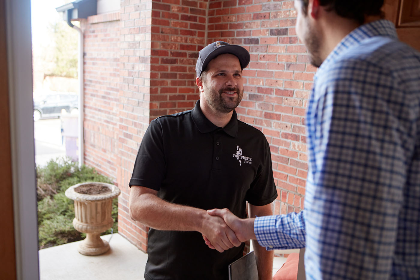 A Footprints Floors team member shaking hands with a customer for a professional led cure refinishing service in Peachtree City, GA.