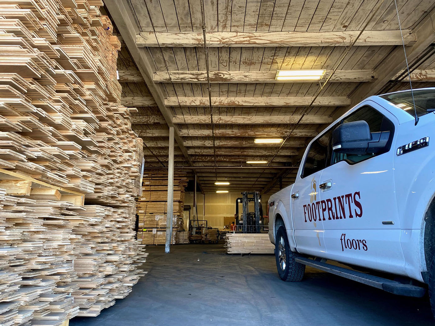 A Footprints pro standing next to one of our service vehicles - trust Footprints Floors, one of the best flooring installation companies in Reno-Sparks Metro, NV to handle your next project.