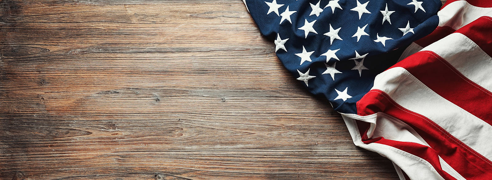 An image of an american flag and hardwood floors - Footprints Floors Peachtree City proudly supports our veterans.